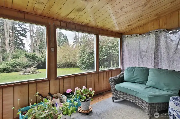 The sunroom looks out over the front yard and firepit.