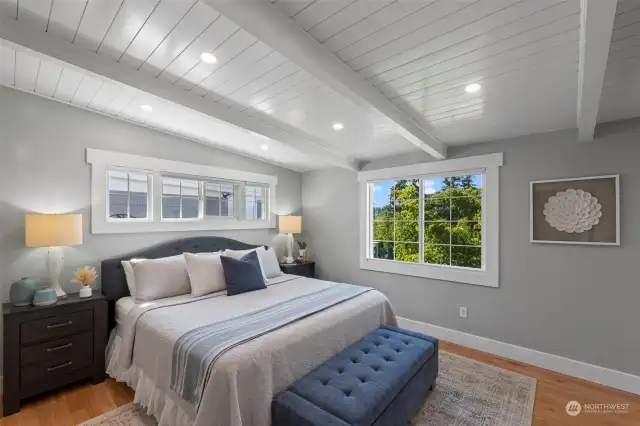 The serene main floor primary bedroom overlooks the Harbor and side yard.  The remote-controlled main window shade offers top-down, bottom-up coverage for adjustable privacy. Dimmable overhead lighting and hardwood floors complete the cozy look.