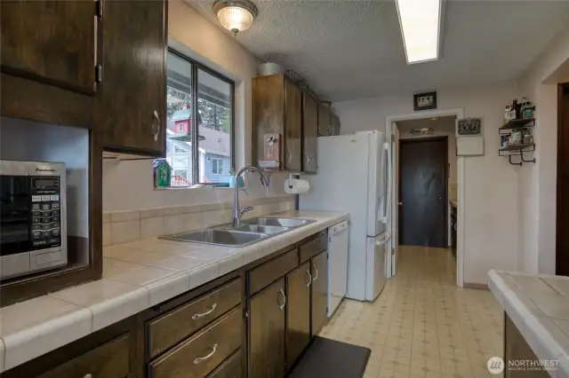 Kitchen, facing utility room that leads to garage.