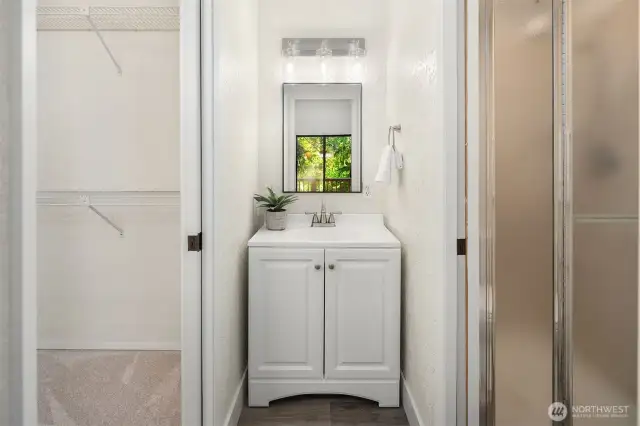 Primary bathroom vanity in between the water closet and the walk in closet.