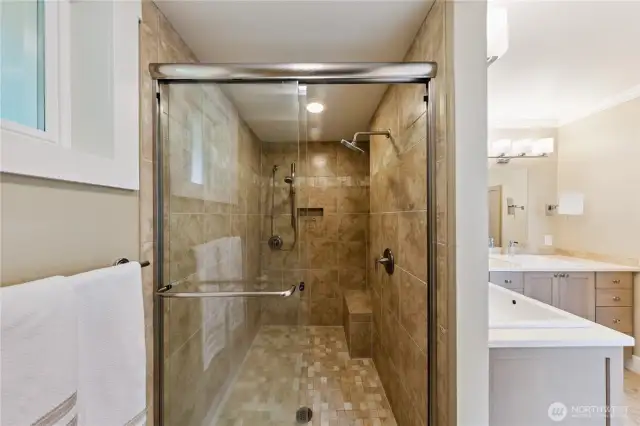 Tiled walk-in shower in the primary bathroom.