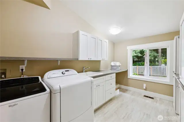 Convenient upstairs utility room offers space for sewing or other projects.