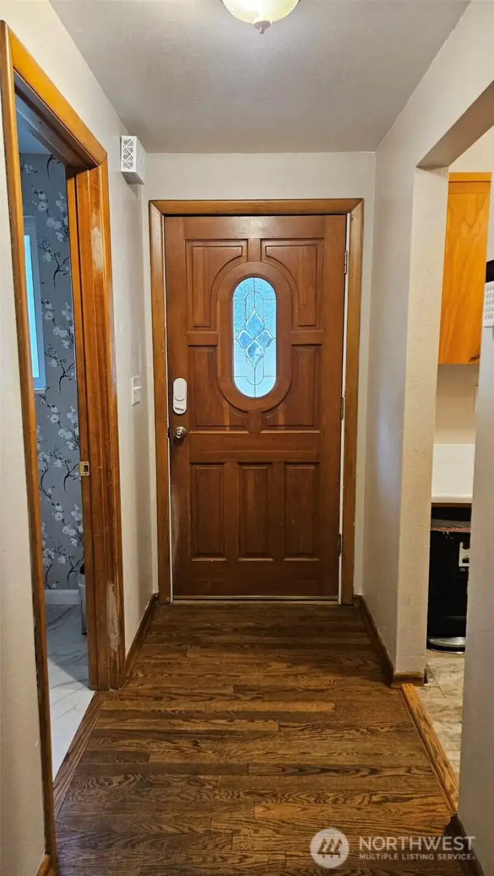 The solid wood entry door has a pretty beveled glass insert.