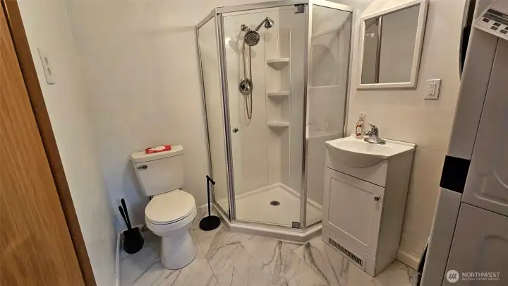 Updated 3/4 bathroom near the front door with luxury vinyl tile flooring