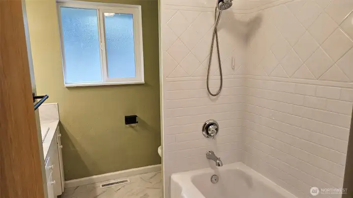Main bathroom with a nice tub/shower combo and luxury vinyl tile flooring