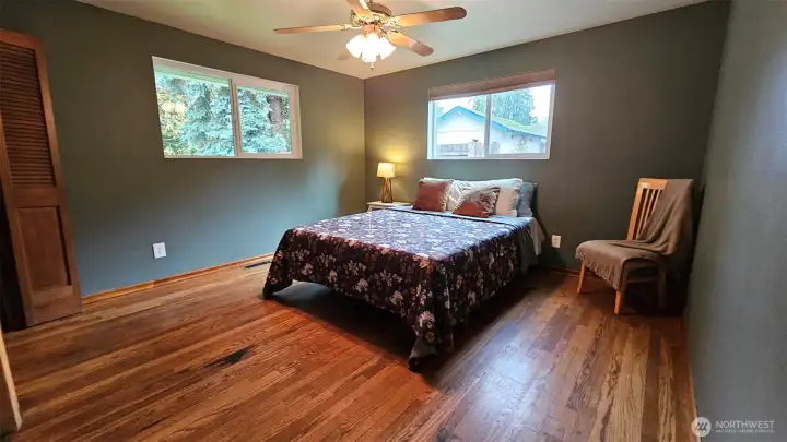 The primary bedroom has hardwood floors, dual closets, a ceiling fan, and two nice-sized windows.