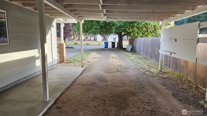 View from inside the large carport, looking toward the driveway, street and park.