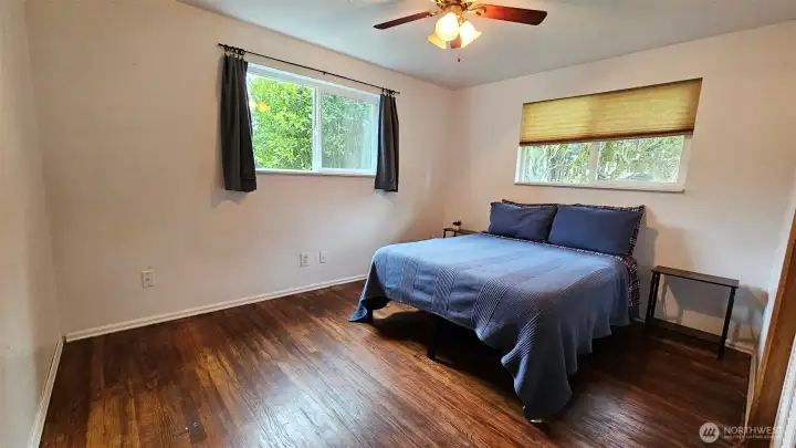 Bedroom number two - with hardwood floors, ceiling fan, closet, and two windows.