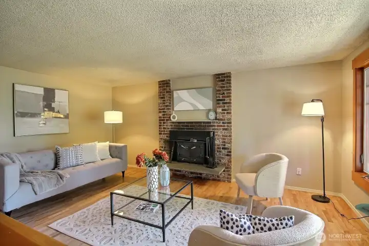 A spacious and inviting room, featuring a stunning wood fireplace with a striking brick centerpiece, creating an inviting and welcoming atmosphere.