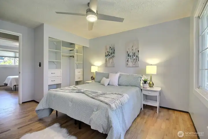 Primary bedroom offers a serene retreat featuring recently refinished hardwood floors, built-in closet storage syteam and overlooks the private backyard.