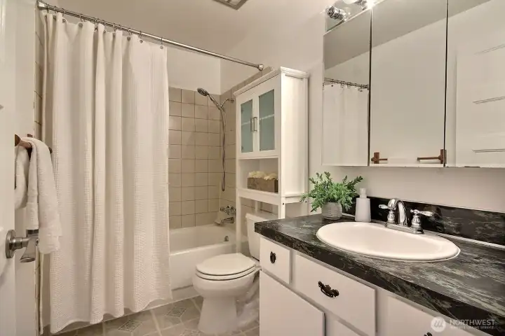 Well-appointed with classic fixtures, this full bath provides comfort and convenience for guests, with ample space and a welcoming atmosphere.