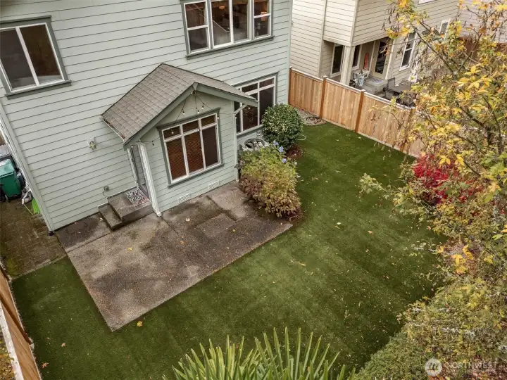 The large backyard's grass is actually a turf product so you'll never have to mow a lawn again!