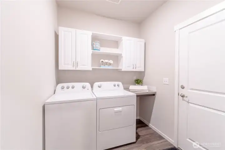 Laundry room featuring enhanced storage through the addition of cabinetry.