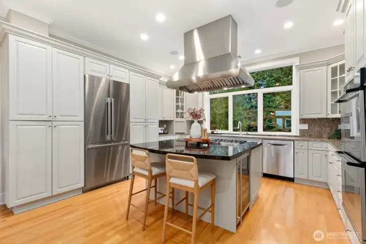 The kitchen is complete with an abundance of storage, newer fridge, and additional bar seating.