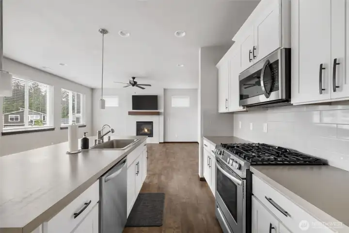 The kitchen lends itself to the space feeling open and easy, with room to prep, serve, clean up, and still stay part of whatever is happening in the living room.