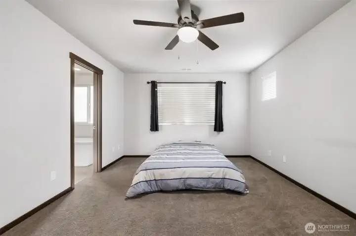 The primary bedroom does not need to be dramatic to do its job well: it gives you space to rest, reset, and step right into a bathroom designed to make mornings feel easier.