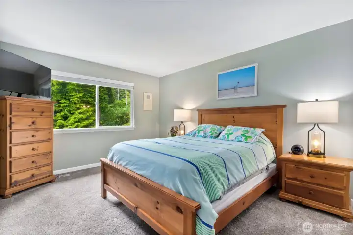 Primary bedroom is spacious and looks out over the lush landscaping of the backyard Primary bedroom is spacious and looks out over the lush landscaping of the backyard