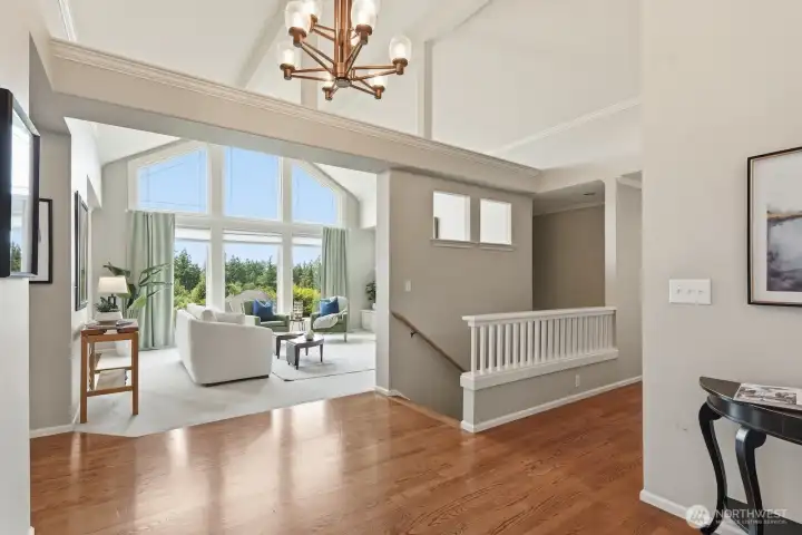 Greeted by wall of windows reflecting off gorgeous hardwoods