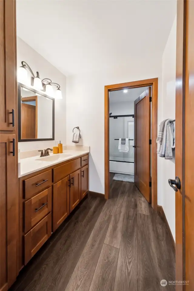 Discover the smart design of the main bath, where a thoughtfully placed door allows separation between the vanity and the shower area, optimizing both functionality and privacy.