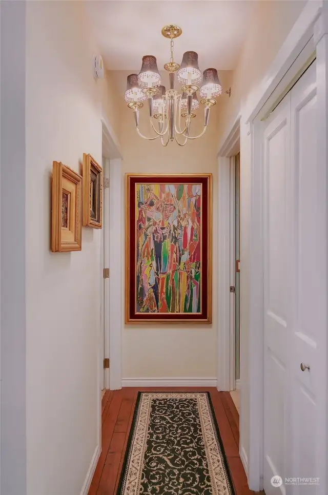 Hallway from the living area to Bedroom and Bath has an added  coat closet and chandelier lighting