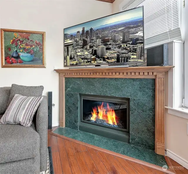 Beautiful marble gas fireplace, new in 2014 includes a built in light show. The custom mantel piece easily houses a 65 inch TV with plenty of room behind for components.  The fireplace features a remote thermostat that keeps the room at your set temperature.