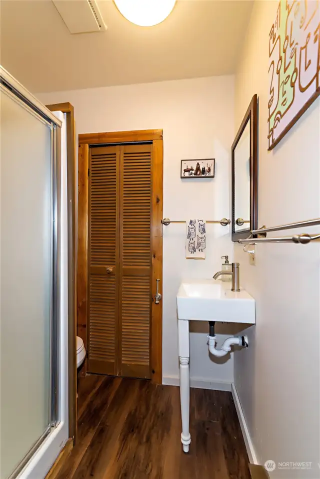 an updated bathroom with a good size storage closet.