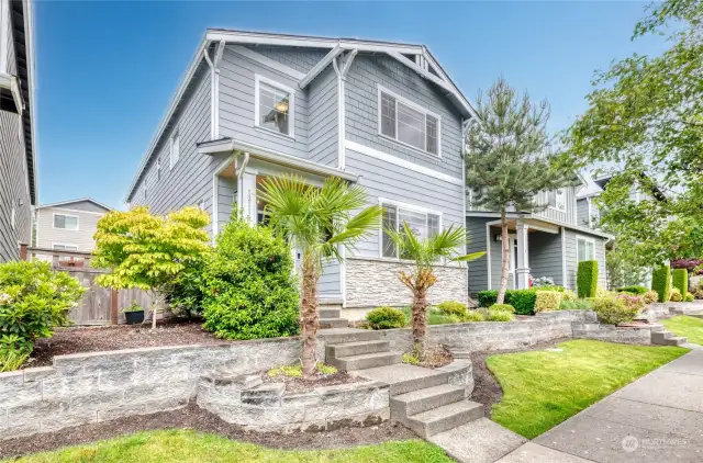 Tropical lush greenery greets you in this exquisite home with beautiful exterior stone accents.