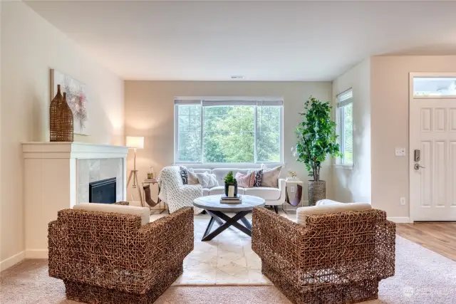 The cozy and relaxing living space illuminated by bright light through the large front windows.