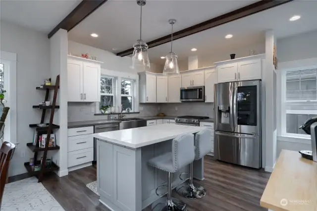 Gorgeous kitchen with solid surface countertops, beautiful cabinetry and farmhouse style sink. All appliances stay.  This kitchen is truly a delight to create a memorable meal in . Note the LVP plank flooring and all the natural light.  This home is truly light and bright!