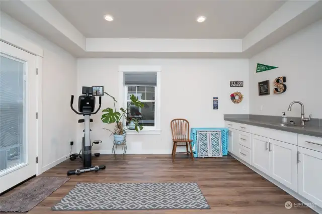 Lower level Rec room with wet bar sink and abundant counter top space.  Even has a small beverage fridge.  This room features LVP flooring and has outside access.  This photo is just showcasing half of this room.  The lower level features 1 bedroom, full bath and outside access.   Makes for a great additional living area.