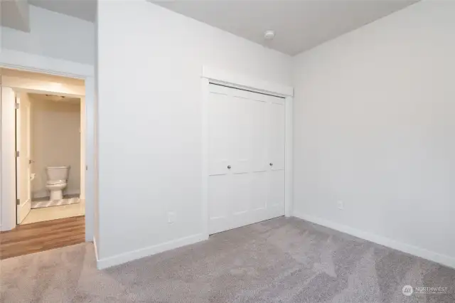 Another view of the downstairs bedroom showing the entrance to full bath across the way.