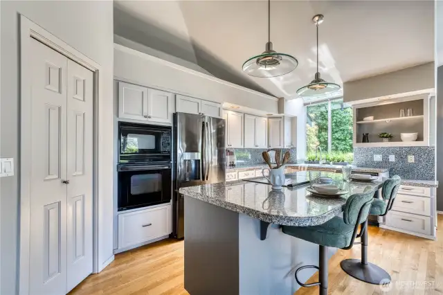 Oak flooring, granite countertops, a pantry, and a greenhouse window over the sink enhance this stylish kitchen.