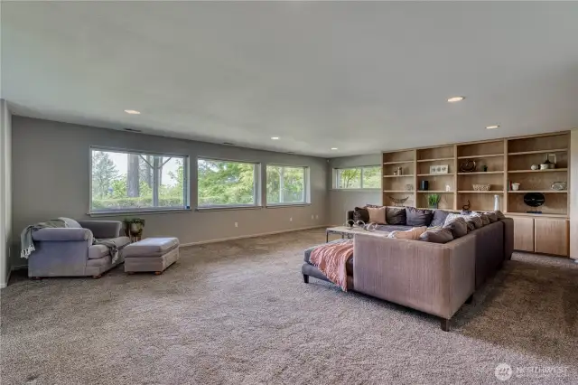 Now let's go downstairs to this giant space with lots of built-ins, windows and a view of the backyard and the water.