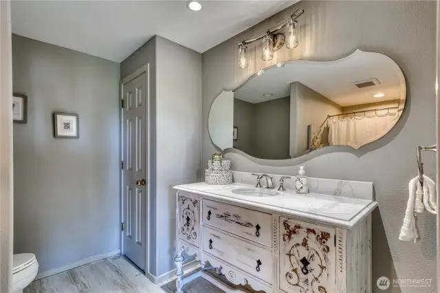 The lower level bath features a piece of restored furniture from Seattle as a sink base.