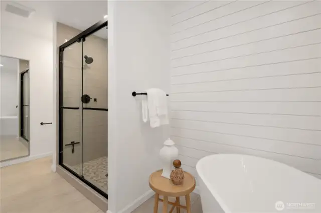 Primary bathroom featuring dual vanity, free-standing soaking tub, double headed shower and a skylight that bathes the space with natural light.
