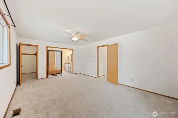 Primary bedroom with walk in closet, jetted tub, and sliding glass door to the deck.