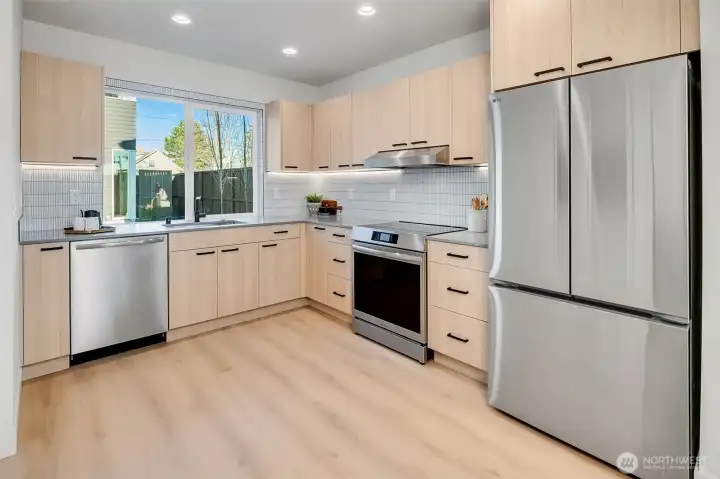 Bright, modern kitchen with soft-close cabinets, Stainless Steel appliances, finish a minimalist design.