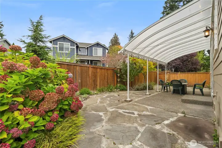 The fully fenced back yard has a lovely flagstone covered patio and lots of room for gardening,