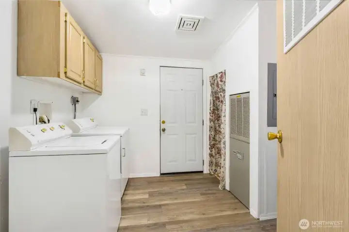 The laundry/utility room has brand new flooring. The hot water tank is behind the curtains for easy access. The far door goes to the backyard.