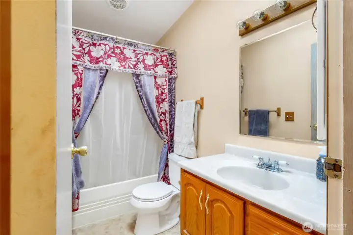 The main bathroom is down with the other three bedrooms in the hallway and has a tub and shower as well.