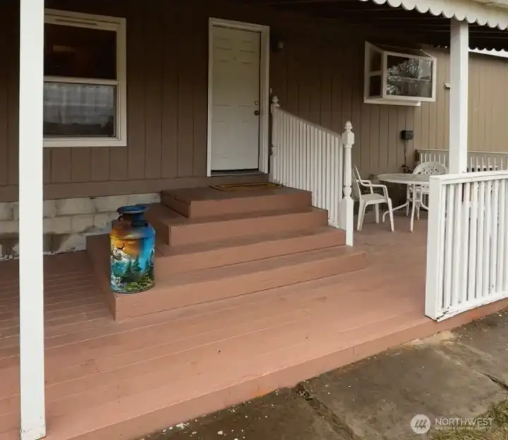 This covered back porch has new wood and paint installed, and leads to the left to the garage.