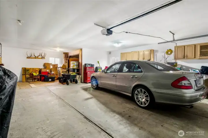 A view from the front looking toward the back of the garage.  The room in the right corner is a great pantry area! And there is a workbench below the cabinetry.