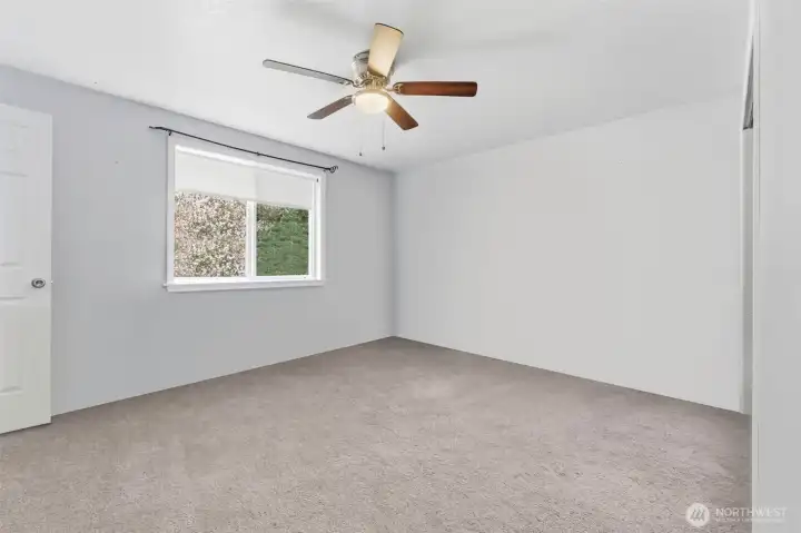 Primary bedroom has been virtually decluttered to remove moving boxes.