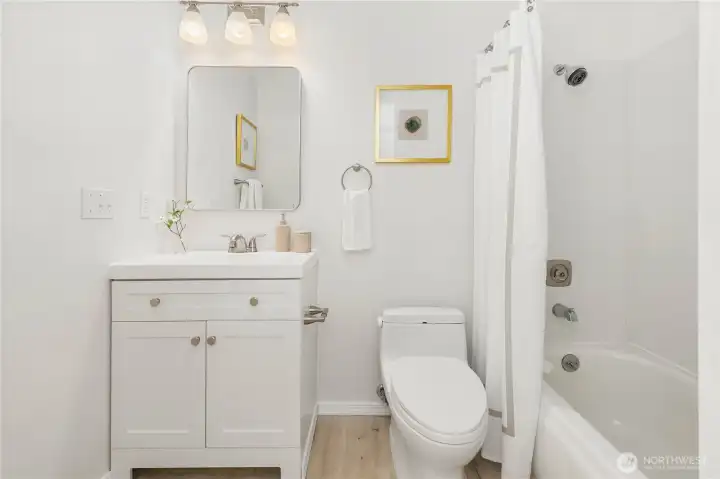 Primary bath with newer flooring, paint and vanity.