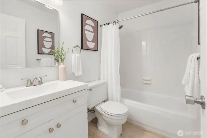 A white on white second full bathroom is adjacent on the main floor