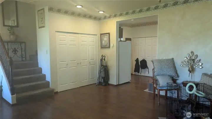 The property offers plenty of storage space throughout. From the living room, you have a clear view of both the kitchen entry and the access to the upstairs level.