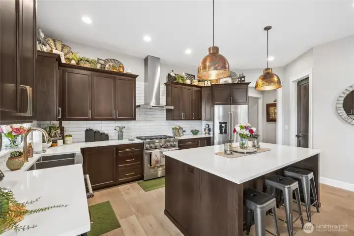 The chef of the home will truly cherish this exceptional kitchen, complete with an oversized central island, KitchenAid gas cooktop, microwave drawer, and a walk-in pantry designed to provide abundant storage. The chef of the home will truly cherish this exceptional kitchen, complete with an oversized central island, KitchenAid gas cooktop, microwave drawer, and a walk-in pantry designed to provide abundant storage.