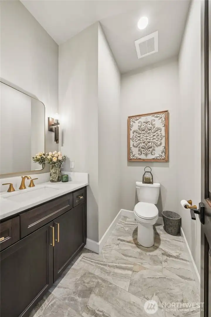 Beautiful powder room featuring elegant tile flooring and a marble vanity, offering a stylish and polished space for guests. Beautiful powder room featuring elegant tile flooring and a marble vanity, offering a stylish and polished space for guests.