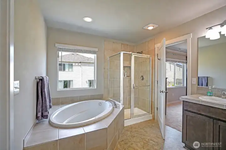 Primary ensuite with soaking tub and glass/tile shower.