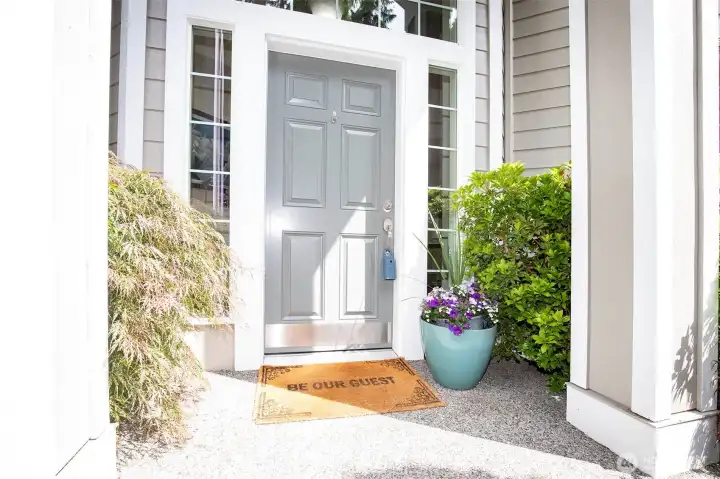 Vaulted Exterior Entry with Lush Plants.